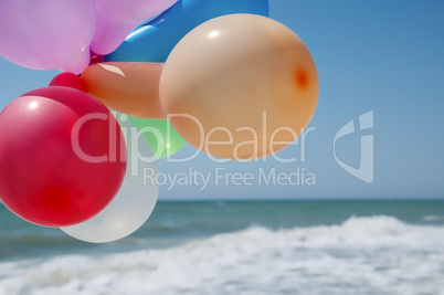 Multicolored balloons against the background of the sea