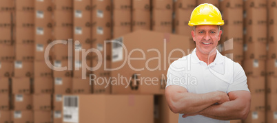 Composite image of worker wearing hard hat in warehouse