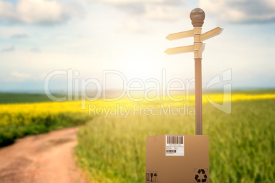 Composite image of cardboard box with road sign