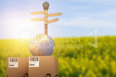Composite image of brown cardboard boxes and globe by road sign