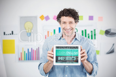 Composite image of businessman showing digital 3d tablet with blank screen in creative office