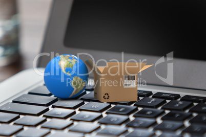 Composite image of 3d image of globe by cardboard box