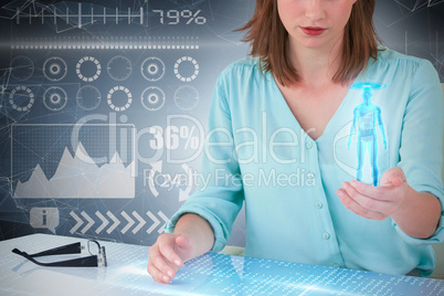 Composite 3d image of businesswoman sitting at desk and using digital screen