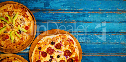 Fresh pizzas on blue wooden table