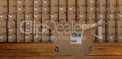 Composite image of open cardboard box by stack of boxes