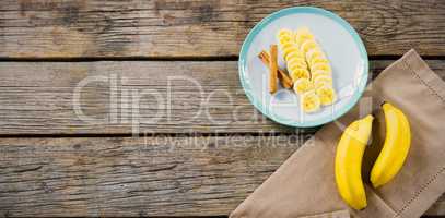 Banana slices in plate on wooden table