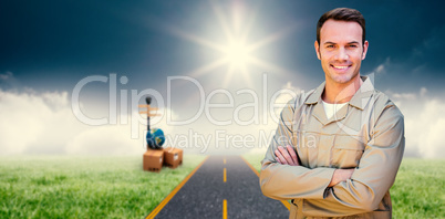 Composite image of confident delivery man standing with arms crossed