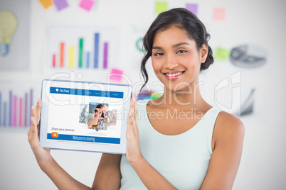 Happy businesswoman showing digital 3d tablet in creative office