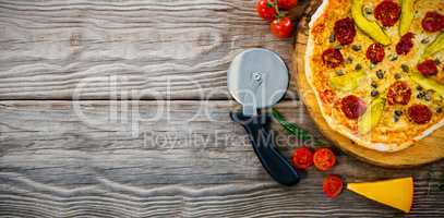 Pizza on by cutter on wooden table