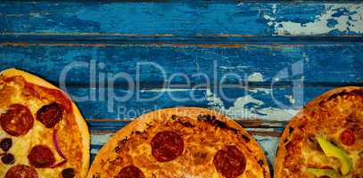 Fresh pizzas on blue weathered table