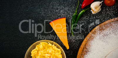 Cheese by spices on black table