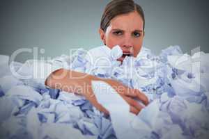 Composite image of portrait of unhappy businesswoman in heap crumpled paper