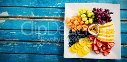 Fresh fruits in white plate on blue table