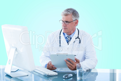 Composite 3d image of male doctor holding clipboard while looking at computer monitor