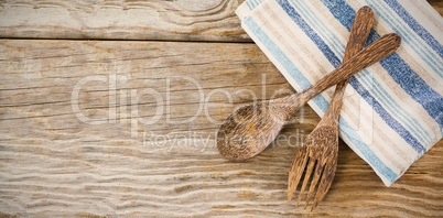 Wooden spoon and fork with napkin on table