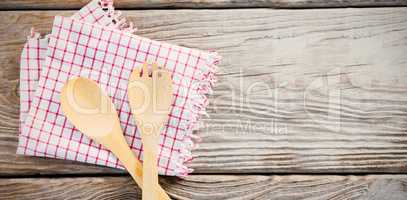 Wooden spoon and fork with napkin on table