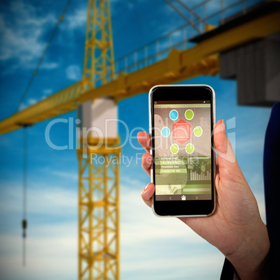 Composite 3d image of mid section of businesswoman holding mobile phone