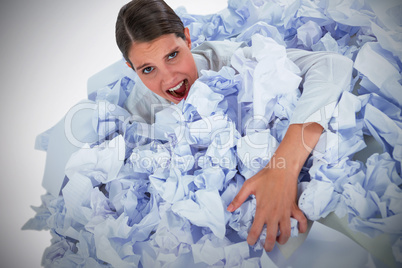 Composite image of portrait of unhappy businesswoman in heap crumpled paper