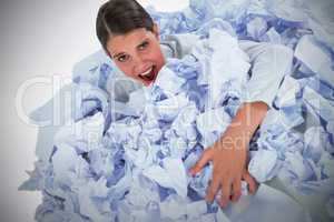 Composite image of portrait of unhappy businesswoman in heap crumpled paper