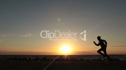 Silhouette of man running at seaside twilight time