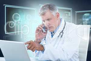 Composite 3d image of male doctor pointing at laptop while using mobile phone