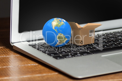 Composite image of 3d image of globe with open courier box