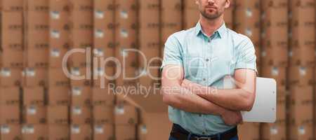 Composite image of serious warehouse manager standing with arms crossed