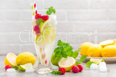 Lemon mojito cocktail with lime, mint and raspberry, cold drink with ice.