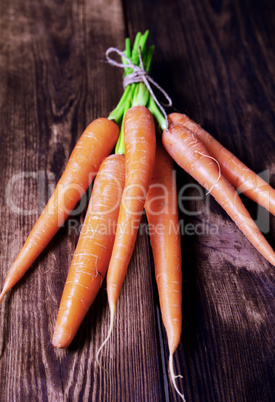 Fresh carrots on a brown wooden background