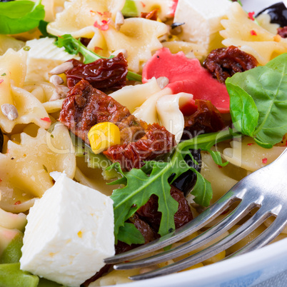Mediterranean Farfalle salad with dry tomatoes and pine cores