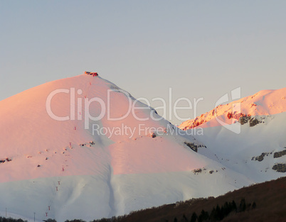 warm sunset over snowy mountains