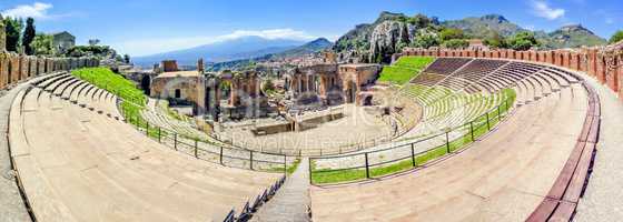view of the ancient theater in Taormina with volcano Etna in the