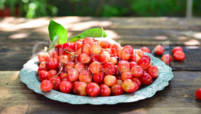 Ripe red cherry in an iron plate