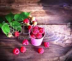 Ripe fresh raspberries in a pink iron bucket