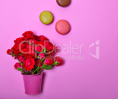 Bouquet of pink roses and multicolored macaroons