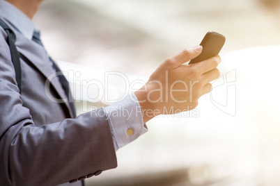 Businesspeople using smart phone at train station.