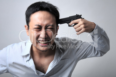 Asian businessman pointing a gun on his head