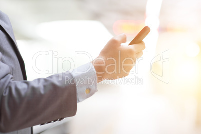 Business people using smart phone at train station.