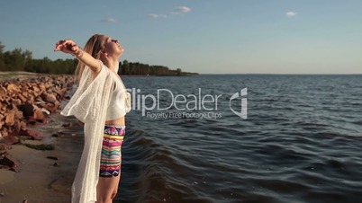 Girl takes deep breath enjoying fresh air on beach