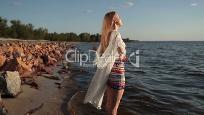 Woman enjoying freedom and life on beach at sunset
