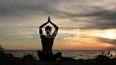 Yoga woman in lotus pose on beach at sunset