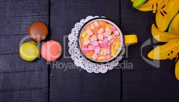 Hot chocolate with marshmallows on a black wooden background, to