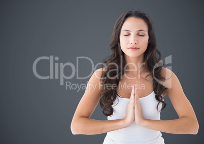 Woman meditating against grey background