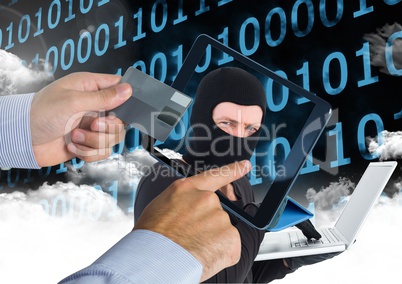 Man using a tablet with hacker head on screen  while holding a credit card