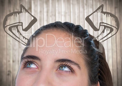 Top of woman's head looking at 3D curved arrows against blurry wood panel