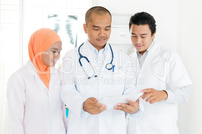 Medical doctors discussing on tablet pc