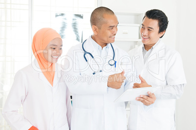 Doctors discussing on tablet pc and thumbs up