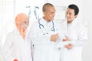 Doctors discussing on tablet pc and thumbs up