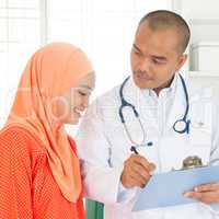 Medical doctor showing report to patient.