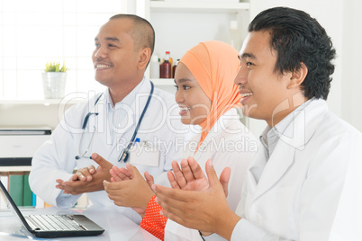 Asian doctors clapping hands